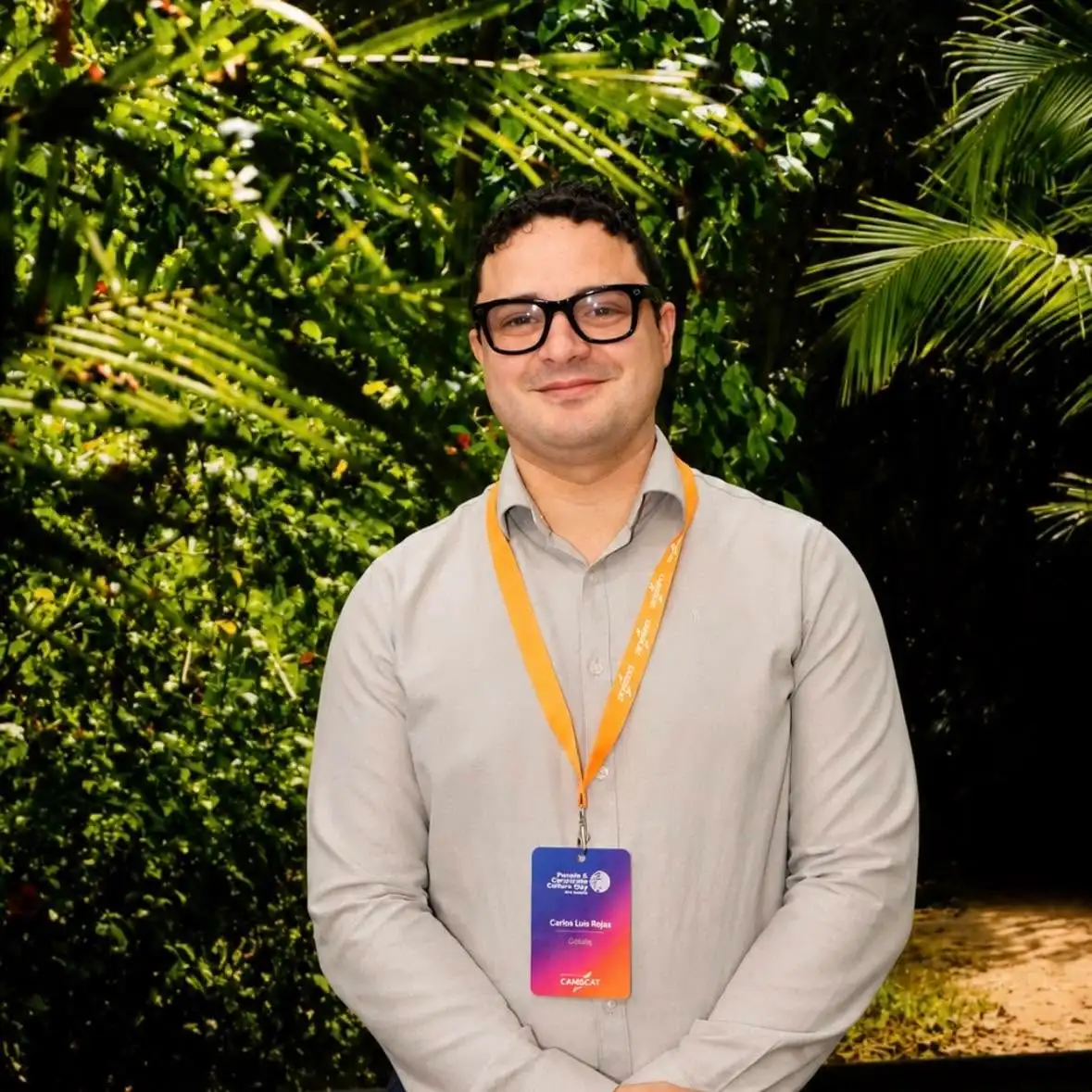 Carlos Rojas wearing a conference badge at an evening event